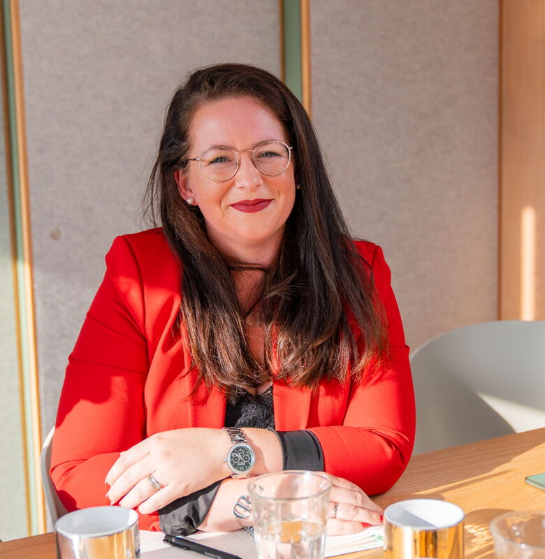 Geschäftsführerin von Grabowski & Rohmann Personalberatung Hamburg im roten Blazer – erfahrene Personalberaterin bei der strategischen Beratung am Konferenztisch